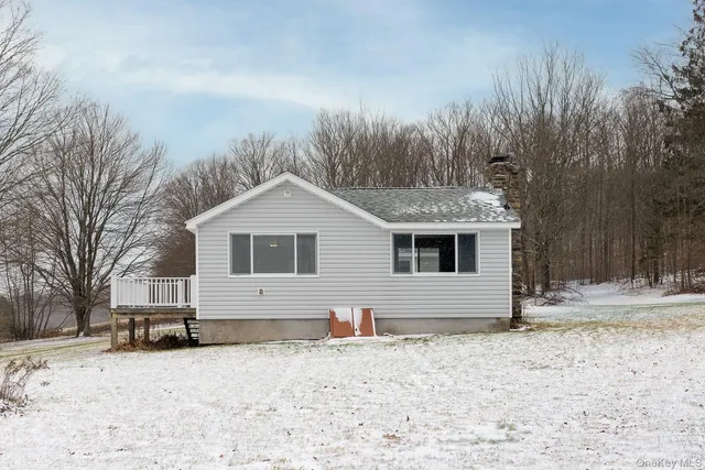 a front view of house with yard and trees in the background