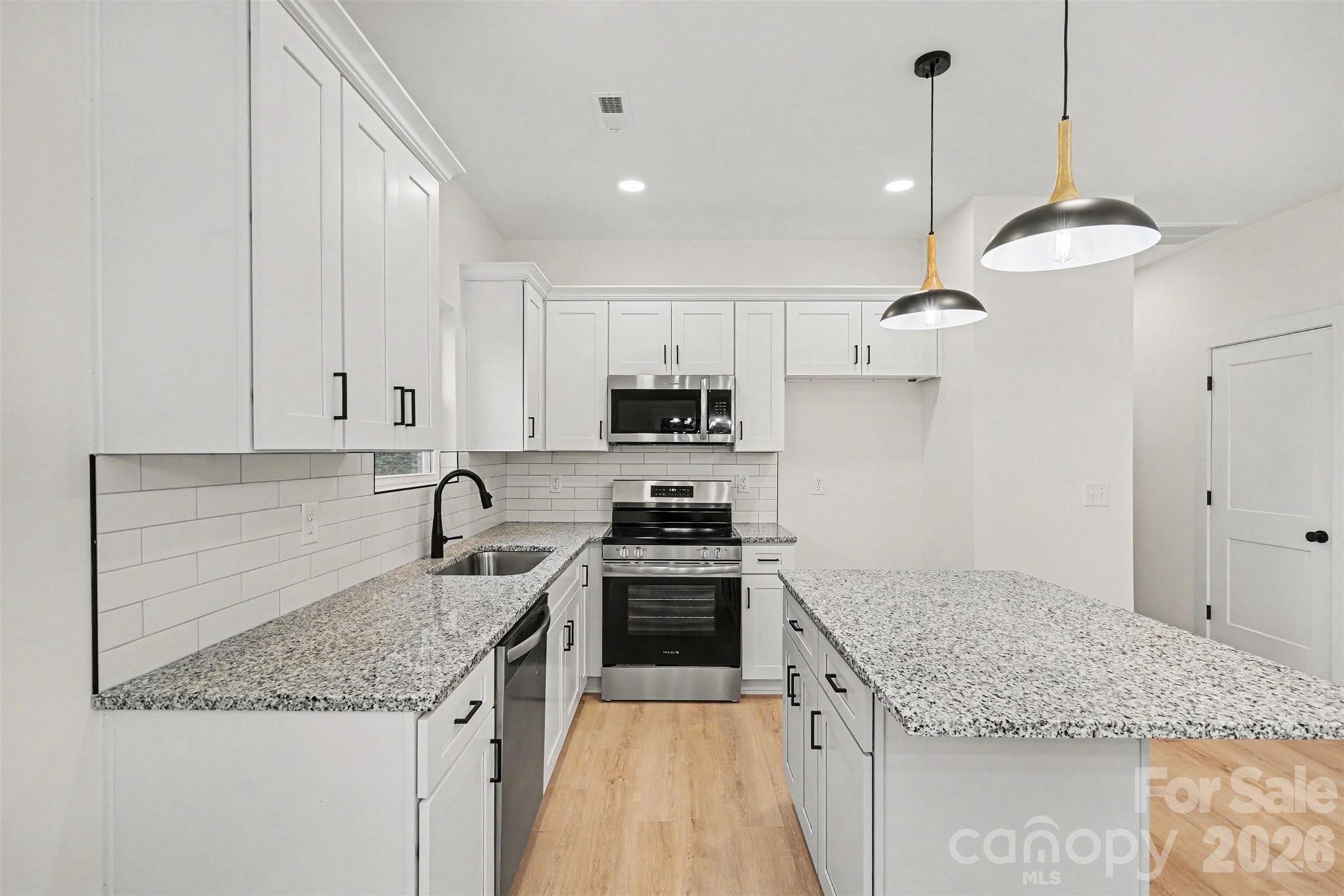 7521 Lawyers Road Charlotte, NC 28227 - Photo 16 of 35 a kitchen with stainless steel appliances granite countertop a sink stove and cabinets