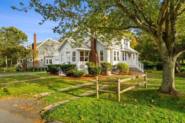 a view of a house with backyard and a tree