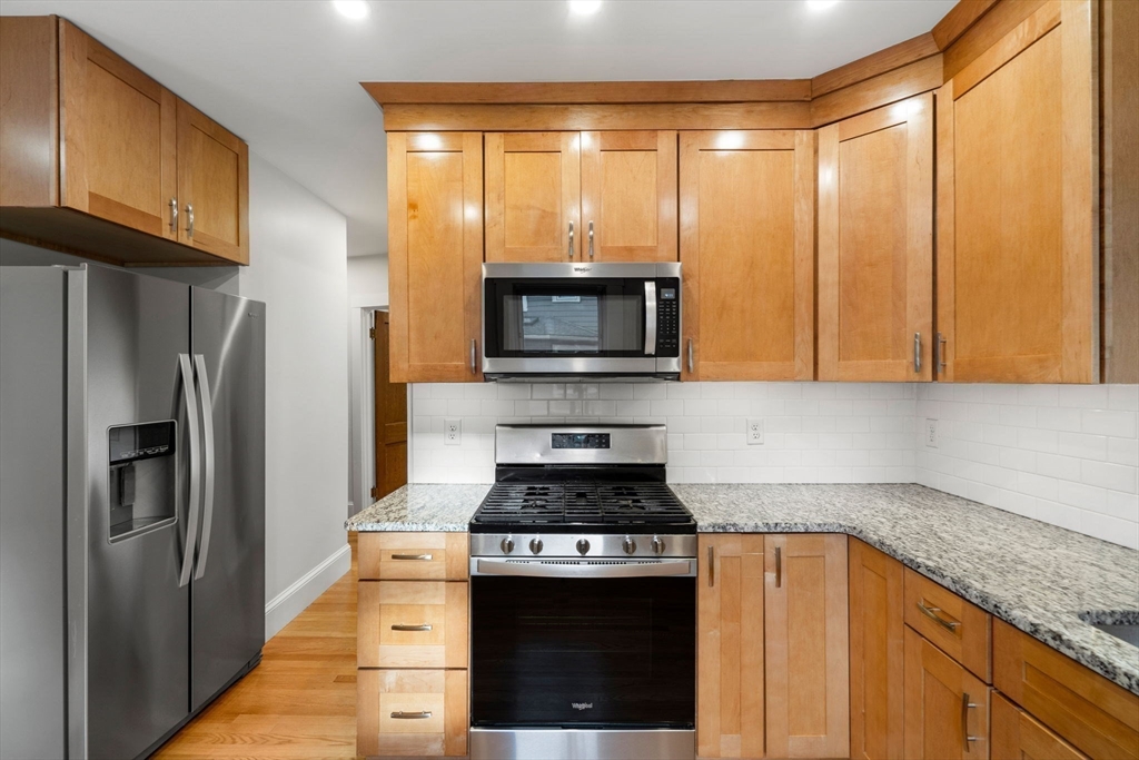 24 Vaille Avenue Lexington, MA 02421 - Photo 14 of 41 a kitchen with stainless steel appliances granite countertop a stove a refrigerator and a microwave