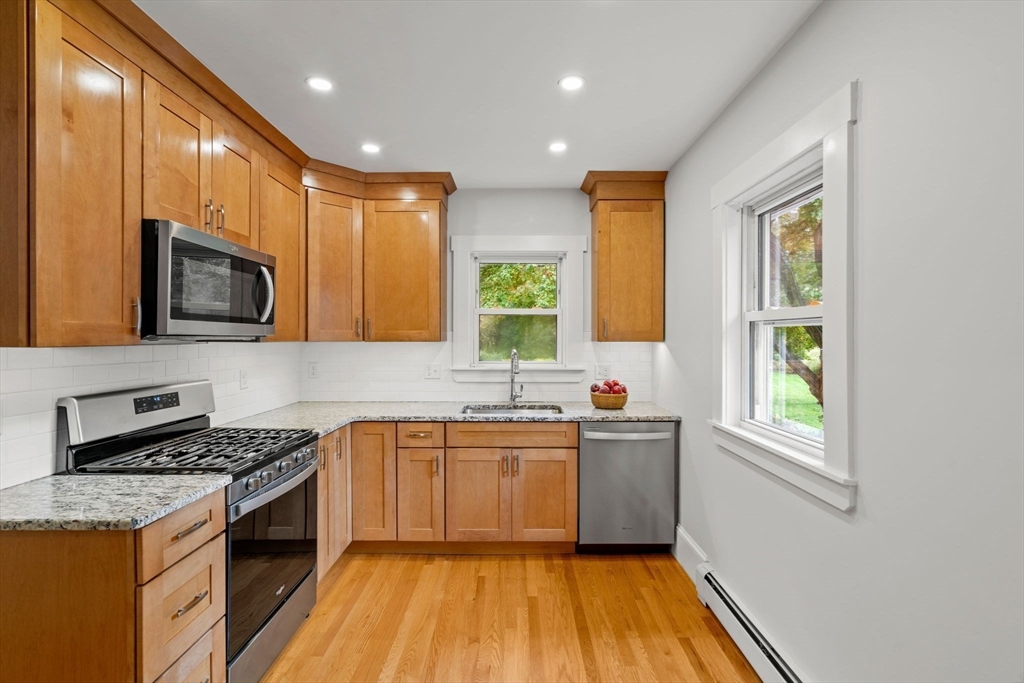 24 Vaille Avenue Lexington, MA 02421 - Photo 15 of 41 a kitchen with stainless steel appliances granite countertop a stove a sink and a microwave