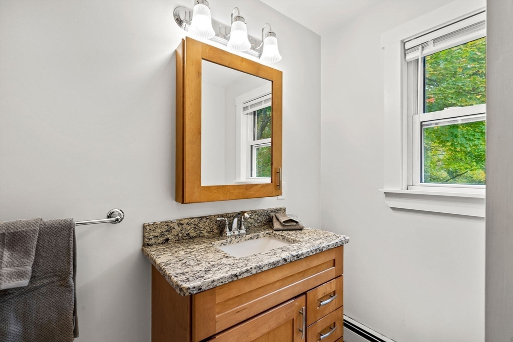 24 Vaille Avenue Lexington, MA 02421 - Photo 17 of 41 a bathroom with a granite countertop sink and a mirror