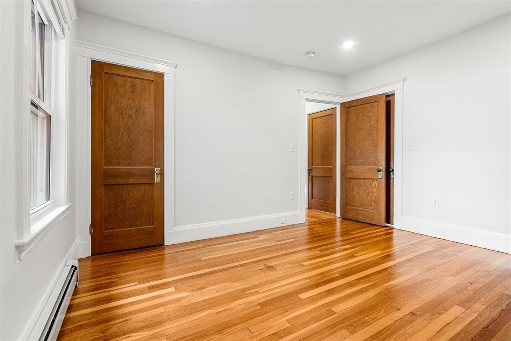 24 Vaille Avenue Lexington, MA 02421 - Photo 21 of 41 an empty room with wooden floor and door