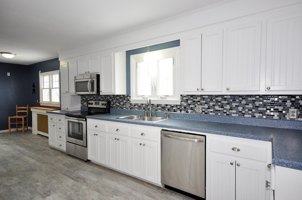33 Warner Road Bolton, MA 01740 - Photo 8 of 23 a kitchen with granite countertop white cabinets and white stainless steel appliances