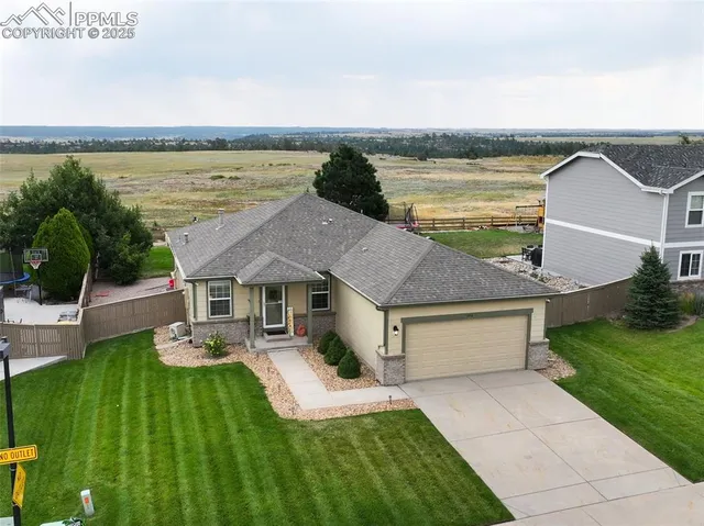 a aerial view of a house with a yard and lake view