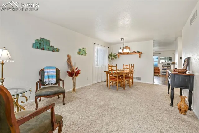 a living room with furniture and a dining table with wooden floor