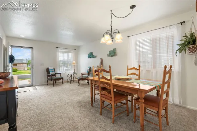 a view of a dining room with furniture and chandelier
