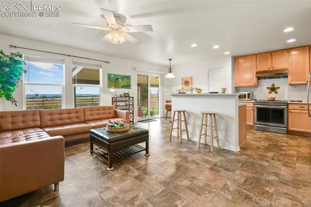 a living room with furniture and a open kitchen view