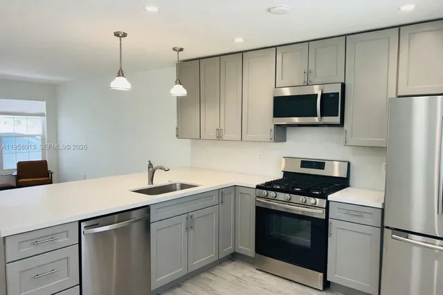 a kitchen with a sink stove and microwave