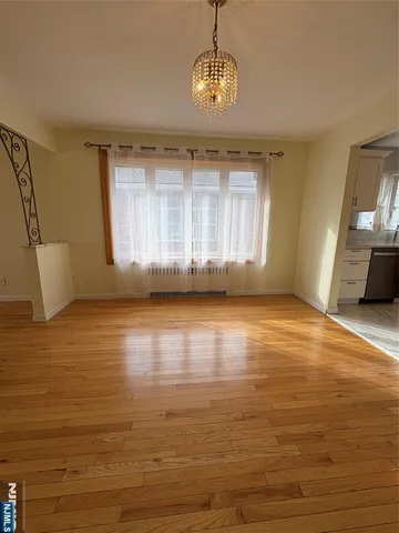 a view of empty room with kitchen and window