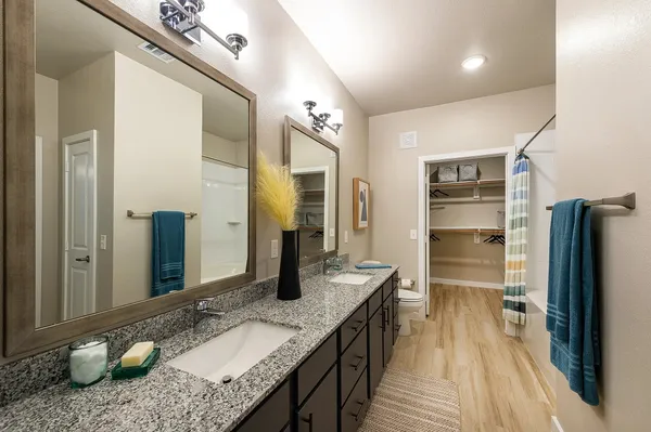 a bathroom with a granite countertop sink a toilet and a mirror