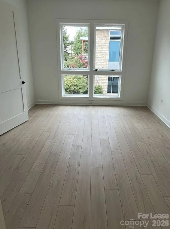 19546 Greentree Way, Unit 203 Cornelius, NC 28031 - Photo 13 of 22 an empty room with wooden floor and windows
