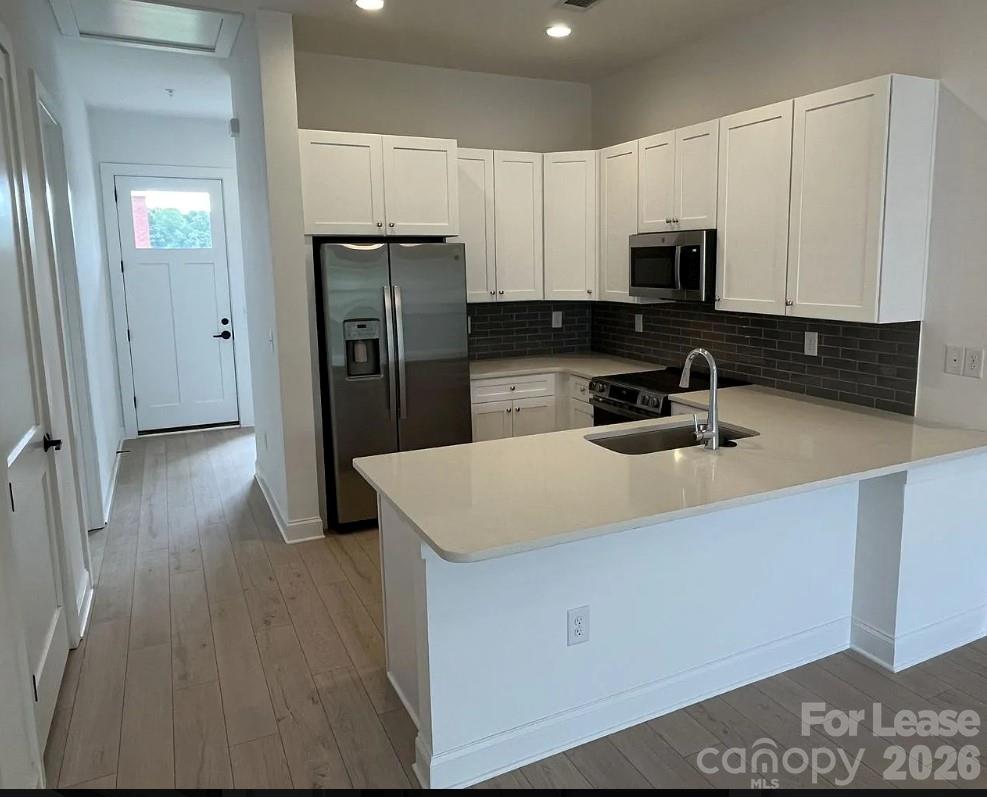 19546 Greentree Way, Unit 203 Cornelius, NC 28031 - Photo 7 of 22 a kitchen with stainless steel appliances a refrigerator sink and microwave