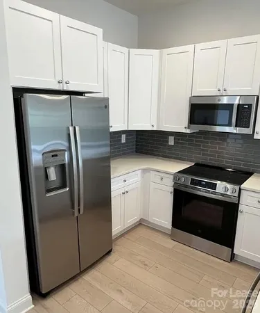 a kitchen with granite countertop a refrigerator and a stove