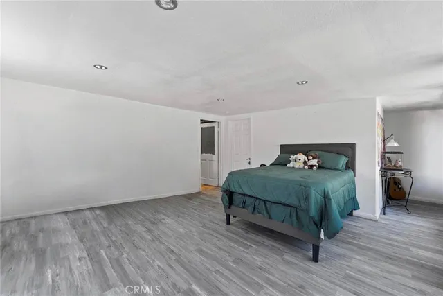 a bedroom with a bed and wooden floor