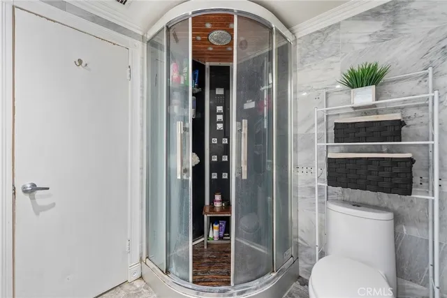 a bathroom with a toilet and a shower