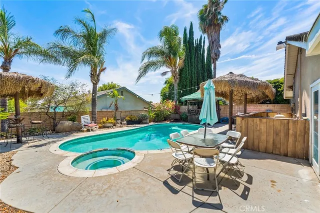 a view of a backyard with a patio and swimming pool