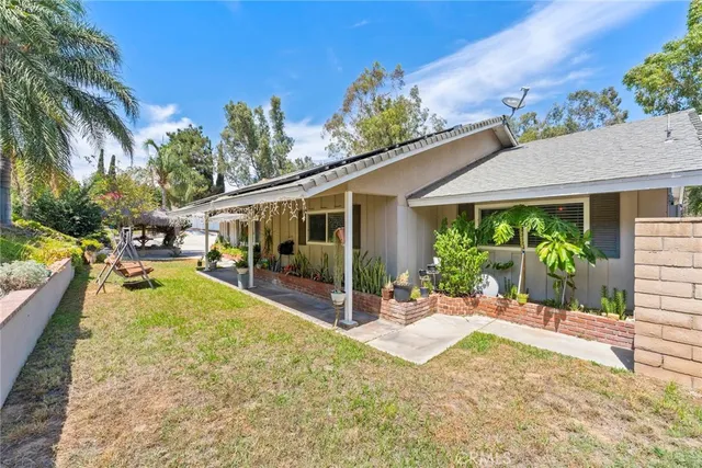 a view of a house with backyard and sitting area