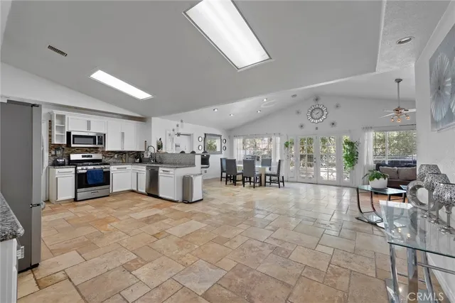 a kitchen with stainless steel appliances kitchen island granite countertop a refrigerator and cabinets