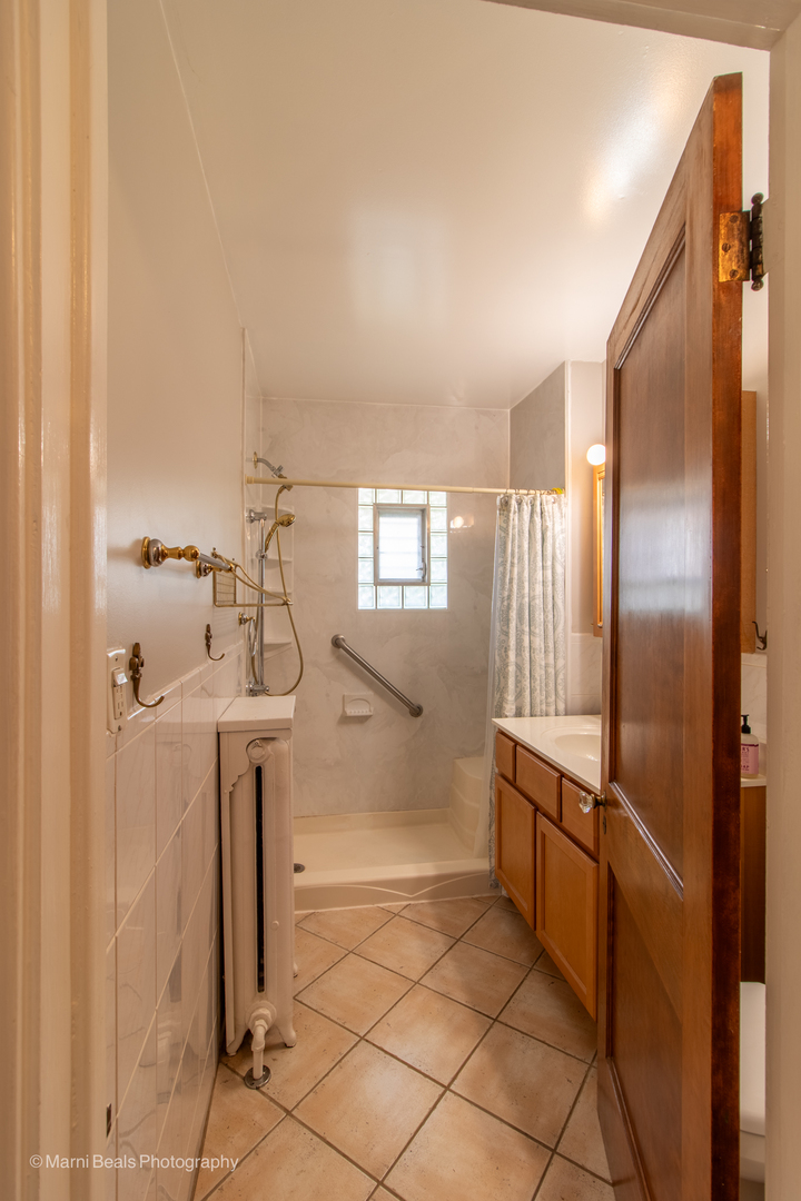 269 Shenstone Road Riverside, IL 60546 - Photo 15 of 25 a bathroom with a sink a mirror and shower