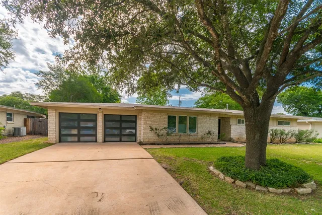 a view of a house with a patio and a yard