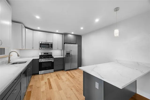 a kitchen with stainless steel appliances a refrigerator sink stove microwave and cabinets