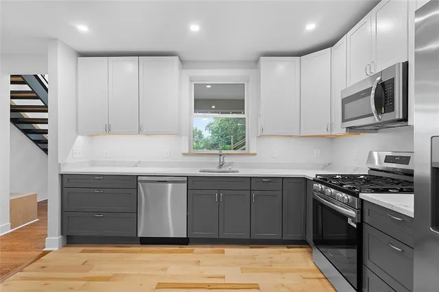 a kitchen with stainless steel appliances granite countertop a stove and a sink