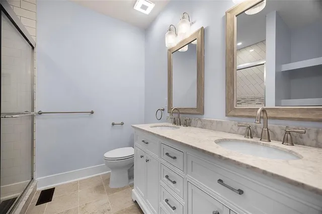 a bathroom with a granite countertop sink a toilet and a mirror