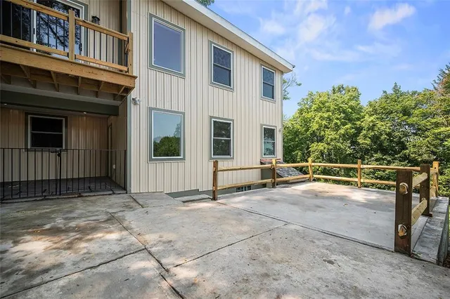 a view of a house with a large window and wooden fence