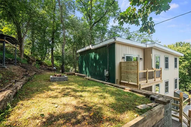 a backyard of a house with table and chairs and a large tree
