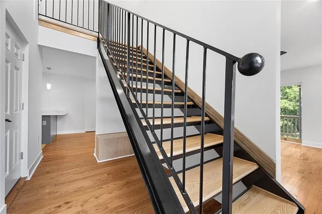 a view of staircase with lots of frames on wall and a window