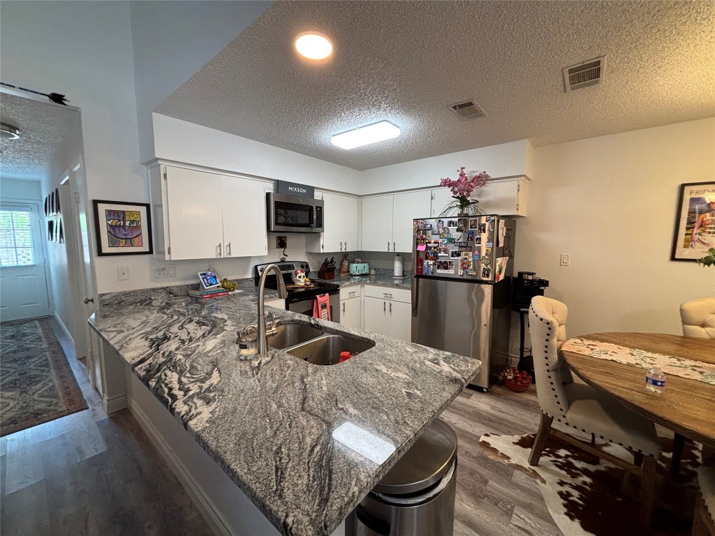 30 Oak Villa Road Canyon Lake, TX 78133 - Photo 10 of 29 a kitchen with kitchen island a stove sink and cabinets