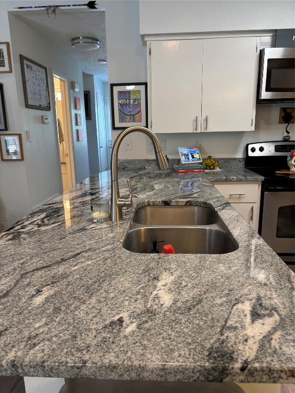 30 Oak Villa Road Canyon Lake, TX 78133 - Photo 6 of 29 a kitchen with granite countertop a sink and a stove top oven