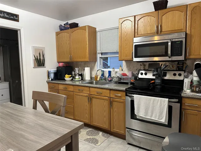 a kitchen with stainless steel appliances a stove microwave and sink