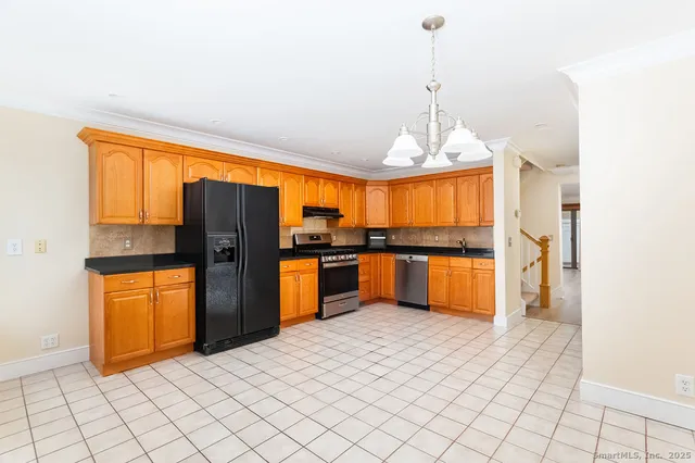 a kitchen with stainless steel appliances granite countertop a refrigerator and a sink