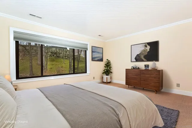 a bedroom with a bed and large window