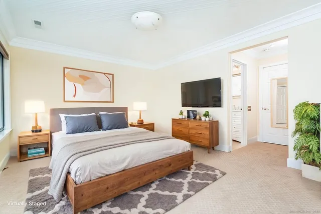 a bedroom with a large bed and a flat screen tv