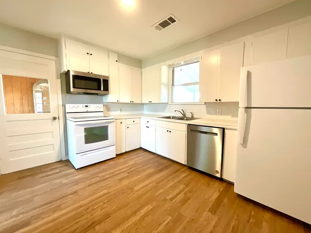 a kitchen with a stove a sink and a microwave