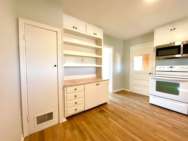 a view of an empty room with cabinet and fire place