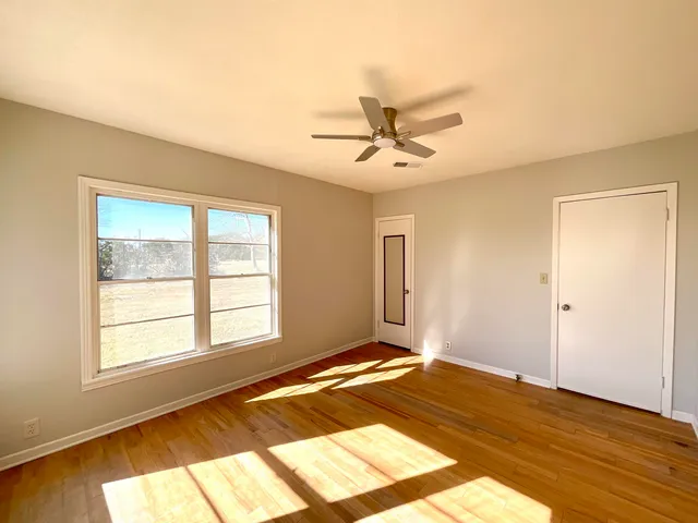 a view of a room with wooden floor and fan