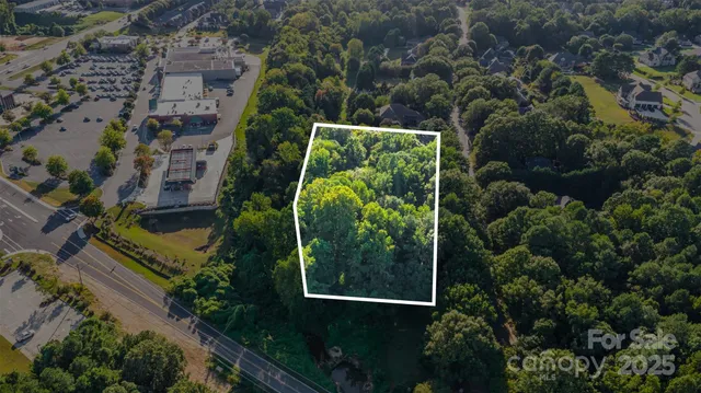 an aerial view of residential house with outdoor space and trees all around