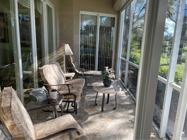 a view of living room with patio furniture and floor to ceiling window