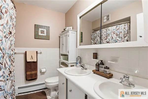 a bathroom with a sink a toilet and a mirror