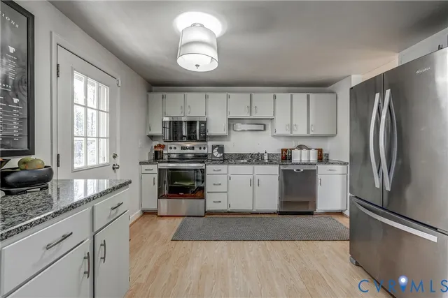 a kitchen with a refrigerator cabinets and wooden floor