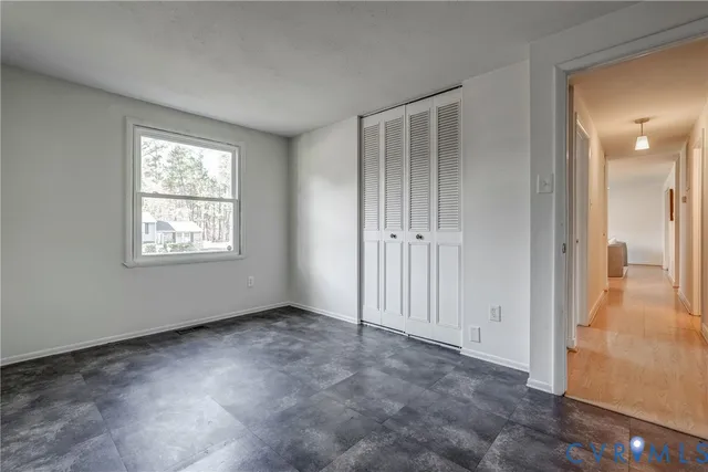 an empty room with windows and closet