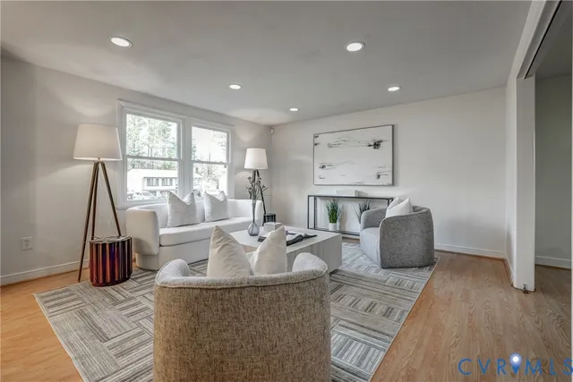 a living room with fireplace furniture and a large window