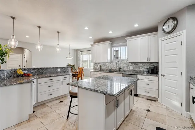 a kitchen with white cabinets and appliances