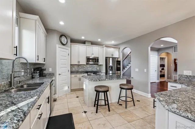 a kitchen with stainless steel appliances granite countertop a sink stove and refrigerator