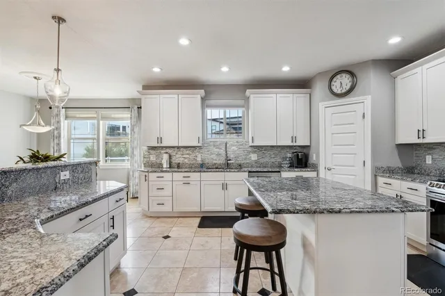 a kitchen with stainless steel appliances granite countertop a sink stove and cabinets