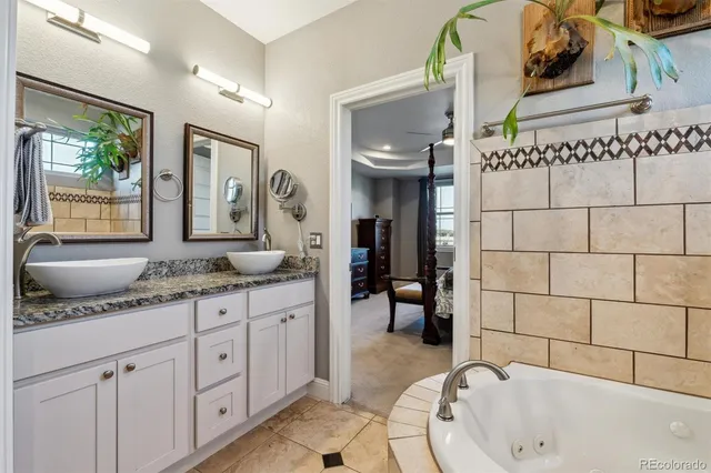 a bathroom with a granite countertop sink mirror and bathtub